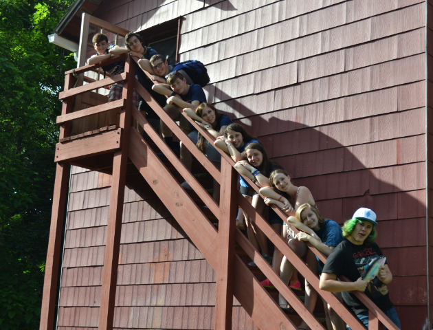 Camp counselors posing on a staircase outdoors.